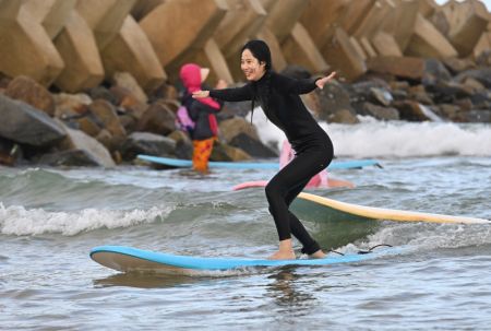 (miniature) Une touriste surfe dans la baie Riyue