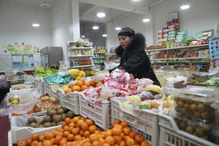 (miniature) La propriétaire d'un supermarché arrange des fruits dans le district de Jishishan