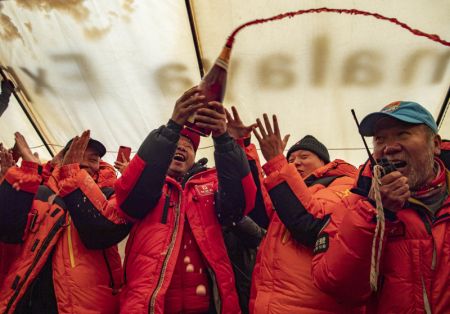 (miniature) Les membres du personnel c&eacute;l&egrave;brent l'arriv&eacute;e au sommet du mont Qomolangma d'une &eacute;quipe d'arpentage chinoise