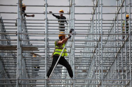 (miniature) Des ouvriers bravent la chaleur en travaillant sur un chantier de construction dans le bourg de Wantou
