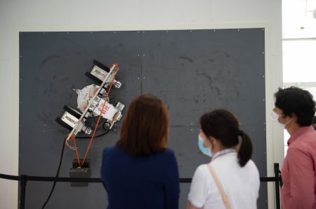 (miniature) Des visiteurs observent un robot utilisé pour éliminer la rouille sur les bateaux et les navires