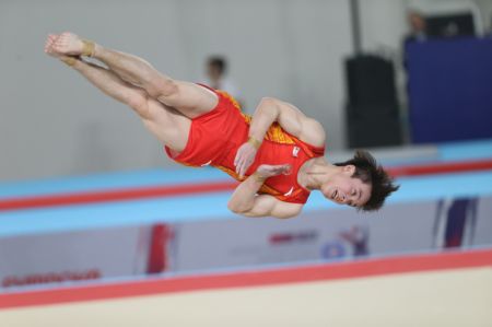 (miniature) Le joueur chinois Qin Guohuan lors du concours au sol masculin par équipe au cours des deuxièmes championnats du monde junior de gymnastique artistique à Antalya