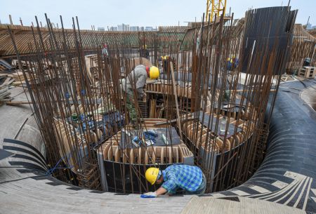 (miniature) Des ouvriers travaillent dans le site de construction de la Biblioth&egrave;que Wormwhole dans la baie de Haikou
