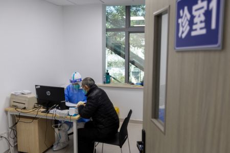 (miniature) Un médecin prescrit des médicaments à petites molécules contre la COVID-19 à un patient dans un centre de services de santé communautaire de l'arrondissement de Minhang