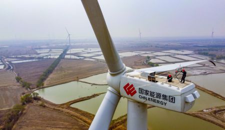 (miniature) Des techniciens examinent une éolienne dans la nouvelle zone de Binhai