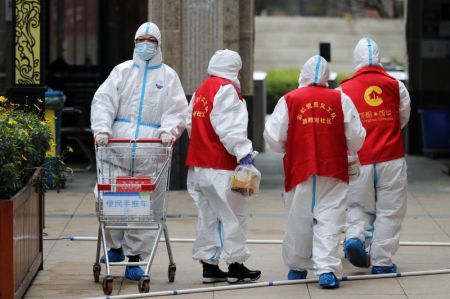 (miniature) Des employés et des bénévoles transportent des produits de première nécessité dans un quartier résidentiel placé en quarantaine dans l'arrondissement de Chenghua à Chengdu