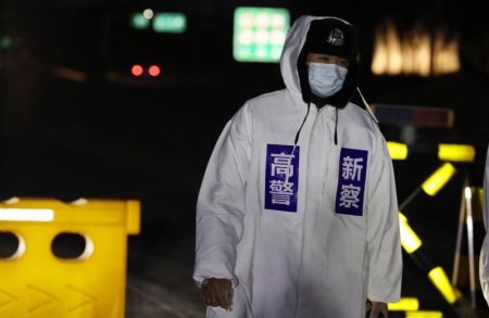 (miniature) Un policier en service &agrave; un point de contr&ocirc;le temporaire pour le contr&ocirc;le de l'&eacute;pid&eacute;mie sur une route reliant l'arrondissement de Gaocheng &agrave; la zone urbaine de Shijiazhuang