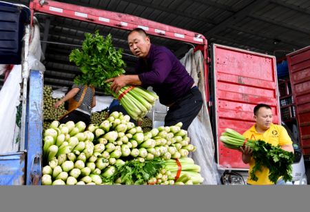 (miniature) Des travailleurs transf&egrave;rent des l&eacute;gumes dans un centre logistique du district de Zhongmu
