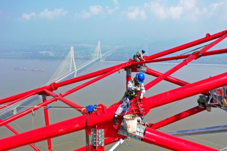 (miniature) Photo aérienne montrant des ouvriers travaillant sur le site de construction d'un pylône de transmission à longue portée du projet de transmission d'électricité à ultra-haute tension (UHV) Baihetan-Zhejiang au bord du fleuve Yangtsé